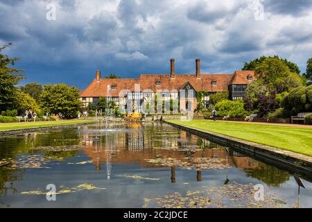 Blick auf das ikonische, historische Laborgebäude am Jellicoe Canal unter schwerem grauen Himmel im RHS Wisley Garden in Surrey, Südostengland Stockfoto