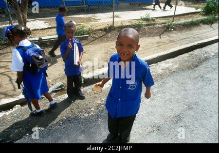 Dennery St. Lucia St. Peters Kinderinfant School Kinder verlassen Schule Junge lächelnd mit Vorderzähne fehlen Stockfoto