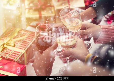 Gruppe von Freunden Weihnachten feiern zu Hause und Kappen Toasten mit Champagner, Weihnachten oder Neujahr Konzept Stockfoto