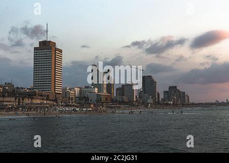 Tel Aviv/Israel-8/10/18: Touristen, die in goldenen Stunden auf der Lahat Promenade und Gordon Beach bei Sonnenuntergang spazieren gehen. Die Promenade von Tel Aviv verläuft entlang des Mediters Stockfoto