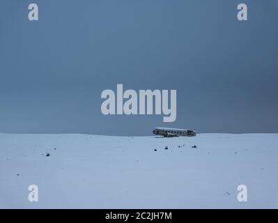 Abgestuerztes Flugzeug auf eine schneebedeckte Wiese in Island Stockfoto