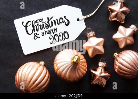 Ein Etikett mit englischen Kalligraphie frohe Weihnachten und einen guten Rutsch ins Jahr 2020. Golden Christmas Ball Ornament auf schwarzem Hintergrund. Stockfoto