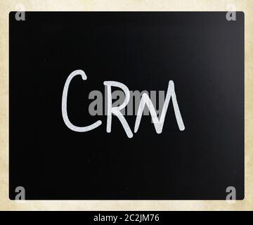 Das Wort "CRM" handschriftlich mit weißer Kreide auf einer Tafel Stockfoto