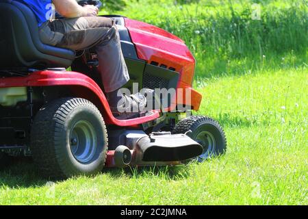 Gärtner fahren reiten rasenmäher in einem Garten. Stockfoto