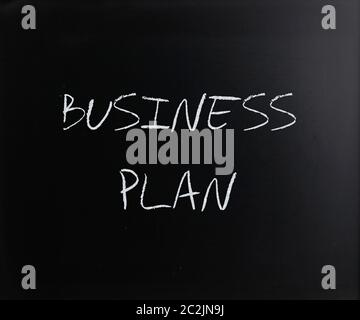 "Business Plan" handschriftlich mit weißer Kreide auf einer Tafel. Stockfoto