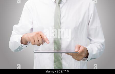 Geschäftsmann Stehhaltung Hand leer Tablet isoliert auf über grauer Hintergrund Stockfoto