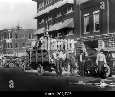 LKW auf der Straße in der Nähe des Litan Hotels, der Soldaten und Afroamerikaner während der Wettkämpfe in Tulsa, Oklahoma, USA, Alvin C. Krupnick Co., Juni 1921, transportiert Stockfoto