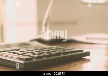 Nahaufnahme von einem Taschenrechner auf Büro Schreibtisch platziert. Ein Kredit Antrag auf Distanz. Wirtschaft Finanzen Konzept. Vintage Hintergrund. Isoliert. Kopieren Sie sp Stockfoto