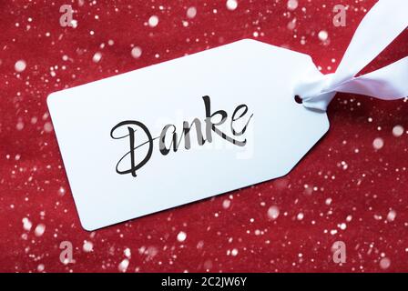 Etikett mit Deutschen Kalligraphie Danke, Danke. Strukturierten Hintergrund rot mit Schneeflocken Stockfoto