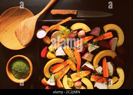 Blick von oben auf die Pfanne voller Fallen, Gemüse der Saison bereit, über einen dunklen Hintergrund gegrillt zu werden. Stockfoto