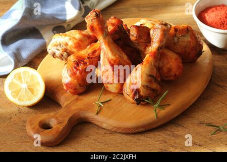 Gegrillte Hähnchenschenkel auf Schneidebrett. Rustikales Abendessen Hintergrund. Stockfoto