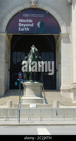 NEW YORK, NY: JUNI 17: Am Eingang des Museums für Naturkunde ist eine Statue des US-Präsidenten Theodore Roosevelt auf einem Pferd mit einer indigenen Person zu sehen, die rechts neben ihm läuft, sowie eine afroamerikanische Person, die links neben ihm läuft. Seit Jahren schmückt dieses Symbol der amerikanischen Überlegenheit das Museum, obwohl es zahlreiche Aufrufe zu seiner Entfernung gab. Ein NYPD-Streifenwagen sitzt vor der Statue zum Schutz während des amerikanischen Aufstands am 17. Juni 2020 in New York City. Quelle: Mpi43/MediaPunch Stockfoto