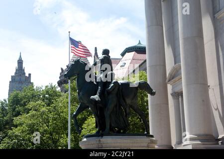 NEW YORK, NY: JUNI 17: Am Eingang des Museums für Naturkunde ist eine Statue des US-Präsidenten Theodore Roosevelt auf einem Pferd mit einer indigenen Person zu sehen, die rechts neben ihm läuft, sowie eine afroamerikanische Person, die links neben ihm läuft. Seit Jahren schmückt dieses Symbol der amerikanischen Überlegenheit das Museum, obwohl es zahlreiche Aufrufe zu seiner Entfernung gab. Ein NYPD-Streifenwagen sitzt vor der Statue zum Schutz während des amerikanischen Aufstands am 17. Juni 2020 in New York City. Quelle: Mpi43/MediaPunch Stockfoto