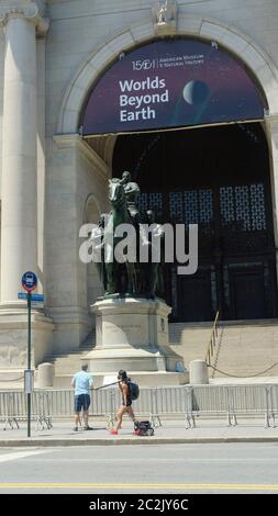 NEW YORK, NY: JUNI 17: Am Eingang des Museums für Naturkunde ist eine Statue des US-Präsidenten Theodore Roosevelt auf einem Pferd mit einer indigenen Person zu sehen, die rechts neben ihm läuft, sowie eine afroamerikanische Person, die links neben ihm läuft. Seit Jahren schmückt dieses Symbol der amerikanischen Überlegenheit das Museum, obwohl es zahlreiche Aufrufe zu seiner Entfernung gab. Ein NYPD-Streifenwagen sitzt vor der Statue zum Schutz während des amerikanischen Aufstands am 17. Juni 2020 in New York City. Quelle: Mpi43/MediaPunch Stockfoto