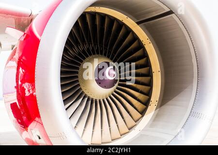 Detailreiche Nahaufnahme des Triebwerks eines Düsenflugzeugs mit roter Verkleidung und weißem Hintergrund Stockfoto