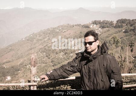 Nahaufnahme Porträt einer stilvollen asiatischen gutaussehenden Mann im Winter Kleidung, steht seitlich auf einem Hintergrund Snow Mountain. Eine attraktive reifen Erwachsenen in Tren Stockfoto