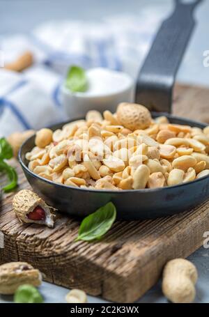 Geröstete Erdnüsse mit Salz in der Pfanne. Stockfoto