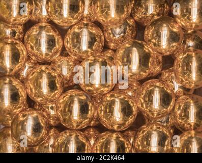 Ausschnitt Textur closeup auf mehrere golden glänzenden Perlen. Stockfoto