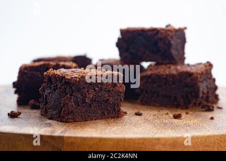 Hausgemachte Schokolade Brownies auf Holzbrett isoliert auf weißem Hintergrund, Nahaufnahme Seitenansicht, selektiver Fokus Stockfoto