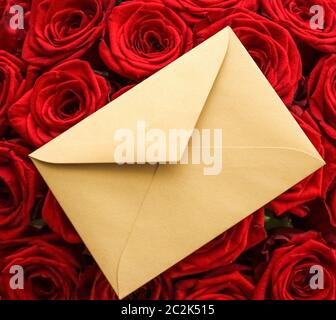 Liebesbrief und Blumenlieferservice am Valentinstag, luxuriöser Strauß roter Rosen und Kartenumschläge auf rotem Hintergrund Stockfoto