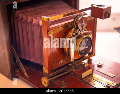 Alte Retro-Vintage-Nahaufnahme-Kamera-Objektiv über Holztisch. Antikes Holz Film Fotokamera Nahaufnahme Objektiv Bild Stockfoto