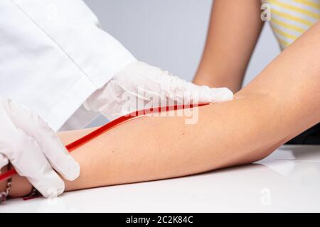 Arzt stellt eine Kanüle auf den Arm des Patienten Stockfoto