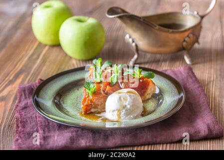 Teil der Tarte Tatin dekoriert mit frischer Minze und serviert mit Kugel Eis Stockfoto