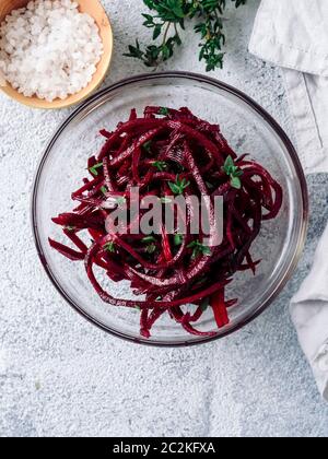 Rohe rote Beete nudeln Salat. Gemüse Nudeln - spaghetti Zuckerrüben auf grauem Hintergrund. Kopieren Sie Platz für Text. Ideen und Rezept für Sauber Essen, Raw vegetar Stockfoto