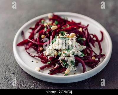 Roher Rote Bete Spaghetti Salat mit Weichkäse, Nüssen, Thymian. Gemüsennudeln - frische Rote Bete Nudeln mit Ricotta und frischem Thymian auf dem Teller. Spa kopieren Stockfoto