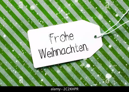 Etikett mit Deutschen Kalligraphie Frohe Weihnachten und ein Glueckliches 2020 bedeutet, frohe Weihnachten und einen guten Rutsch ins Jahr 2020. Grüne Verpackung Papier als Hintergrund ein Stockfoto