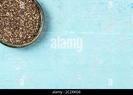 Chia Samen, close-up in einer Schüssel, Overhead shot auf einem blauen Hintergrund mit Kopie Raum Stockfoto