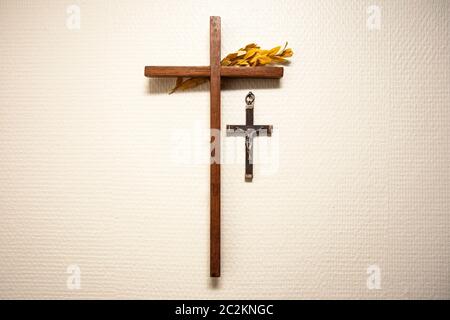 Holzkreuz an der Wand hängen mit Jesus im Wohnzimmer, religiösen und spirituellen Konzept closeup Stockfoto