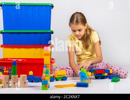 Zehn Jahre alten Mädchen spielen Spielzeug auf dem Boden sitzend Stockfoto