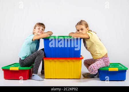 Zwei Mädchen sitzen auf großen Boxen für Spielzeug und sah in dem Rahmen Stockfoto