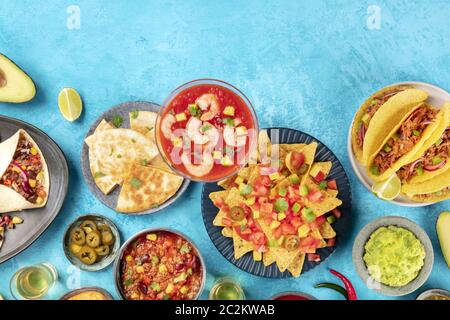 Mexikanische Küche, viele Gerichte der Küche von Mexiko, flache Lay-Top-Aufnahme auf einem lebendigen blauen Hintergrund mit einem Ort für Text. Nachos Stockfoto