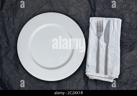 Leeren Teller und Besteck auf schwarzem Seidenpapier. Stockfoto