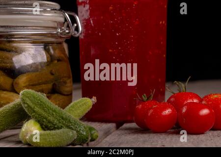 Gurken Tomaten Cherry Tomaten Marmelade eingemachte corinichons auf hölzernen Hintergrund im Studio Stockfoto