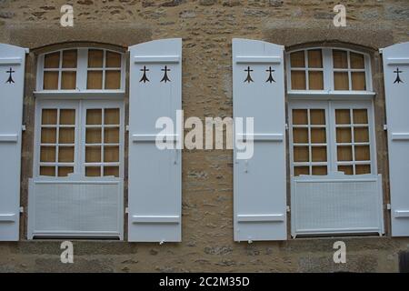 Zwei Fenster mit Jalousien im alten Stil an der Steinwand Stockfoto