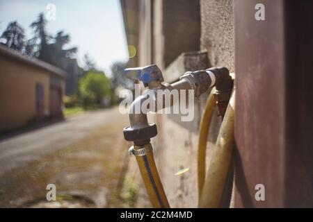 Wasserhahn in Metall von Zeit und abgenutzt, die durch die Nutzung der Garten eines Hauses zu bewässern ruiniert. Stockfoto