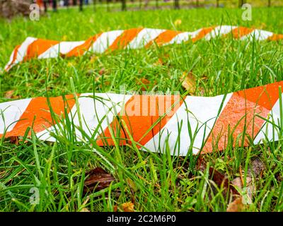 Grenze gestreift Ribbon auf grünem Gras. Hintergrund. Für Text platzieren. Stockfoto