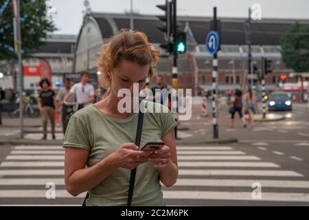 Eine junge Frau reist mit ihrem Handy, um neue Orte des Interesses in der Welt zu entdecken. Foto- und Online-Navigation auf dem Smartphone Stockfoto