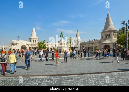 Touristen besuchen den Platz der Matthias-Kirche mit der Fischerbastei und der Statue des Heiligen Stephan I. im Burgkomplex Buda in Budapest, Ungarn Stockfoto