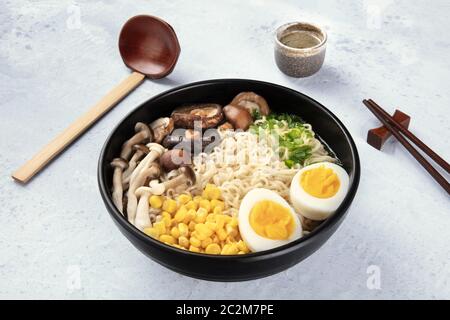 Ramen. Soba Nudeln mit gekochten Eiern, Champignons, und Gemüse, mit Willen, traditionellen hölzernen Löffel und Essstäbchen Stockfoto