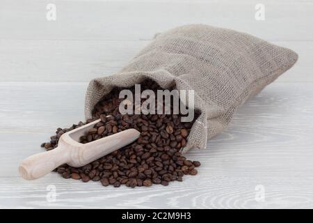 Kaffeebohnenschaufel und Beutel auf Holzoberfläche Stockfoto