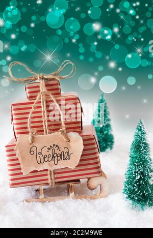 Schlitten mit Weihnachtsgeschenk und Label mit englischen Kalligraphie Happy Weekend. Schnee mit Weihnachtsbaum und Grün funkelnden Hintergrund Stockfoto