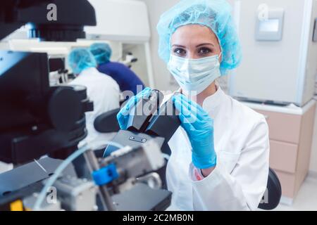 Frau Arzt arbeiten an Manipulator befruchten menschliche Eier in Fruchtbarkeit Klinik Labor Stockfoto