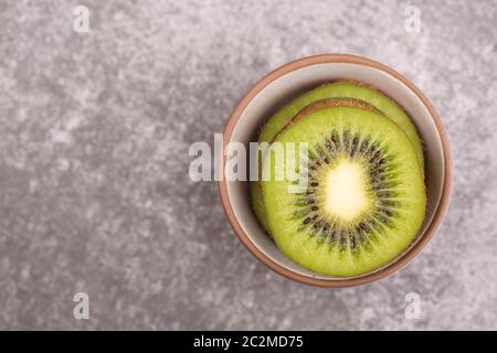 Kiwi-Scheiben auf einem grauen texturierten Hintergrund, leerer Kopierraum Stockfoto