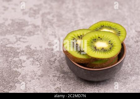 Kiwi-Scheiben auf einem grauen texturierten Hintergrund, leerer Kopierraum Stockfoto