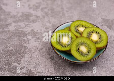 Kiwi-Scheiben auf einem grauen texturierten Hintergrund, leerer Kopierraum Stockfoto