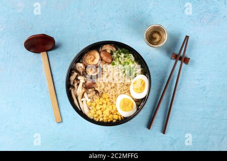 Ramen-Suppe. Soba Nudeln mit Eiern, Shiitake-Pilze und Gemüse, von oben mit Sake, traditionelle Holzlöffel, a geschossen Stockfoto